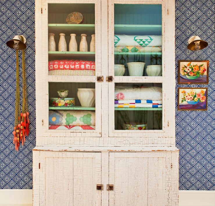 Vintage quilts in an antique white hutch