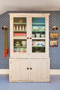 Vintage quilts in an antique white hutch