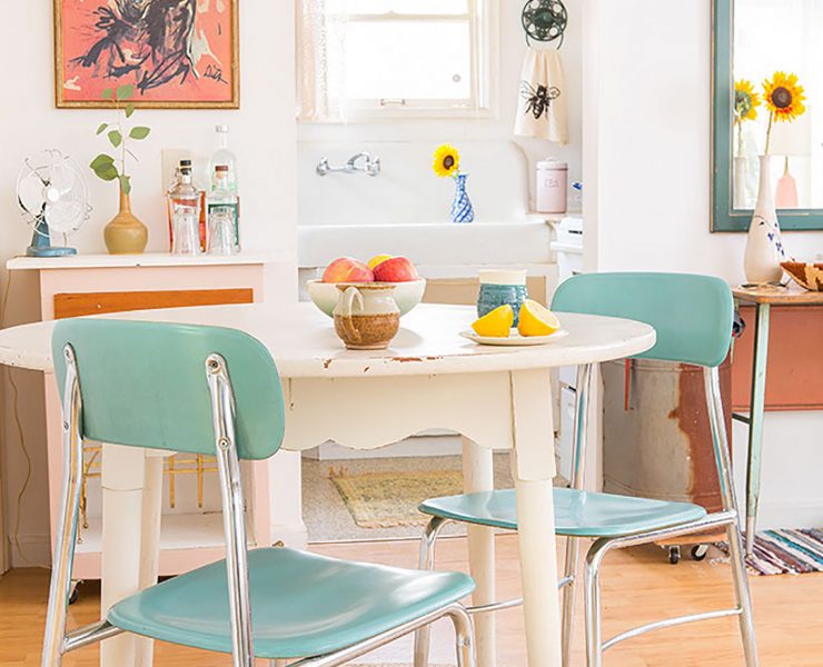 Vintage dining area with white table, blue chairs, jute rug and horse painting