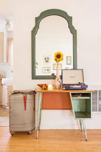 Vintage school desk with mirror overhead and a giant mailbox repurposed into a trashcan