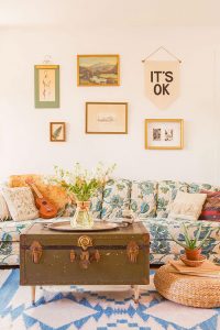 Vintage gallery wall over blue and green sofa in a vintage cottage