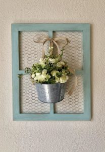 Pale green window frame with chicken wire in the center