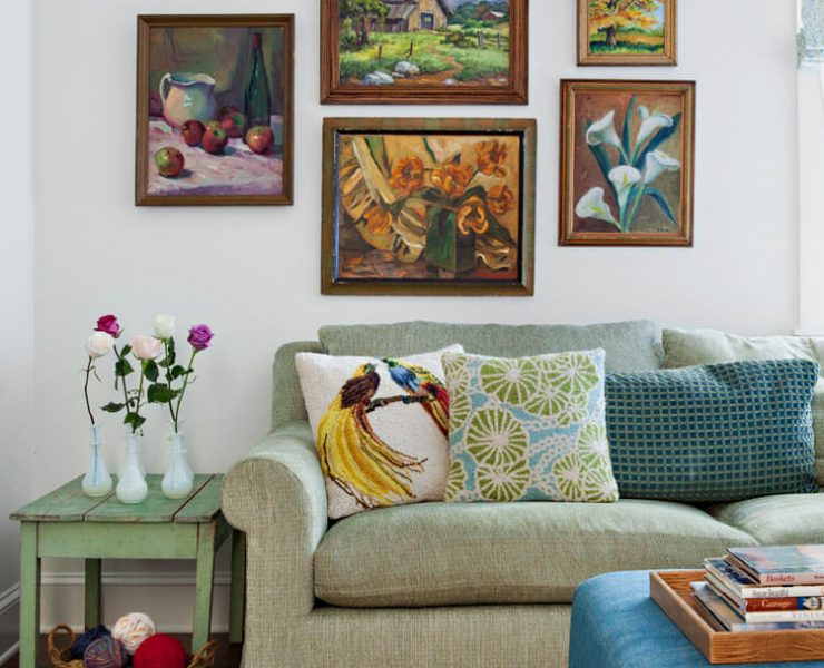 Green sofa with paintings hung above it