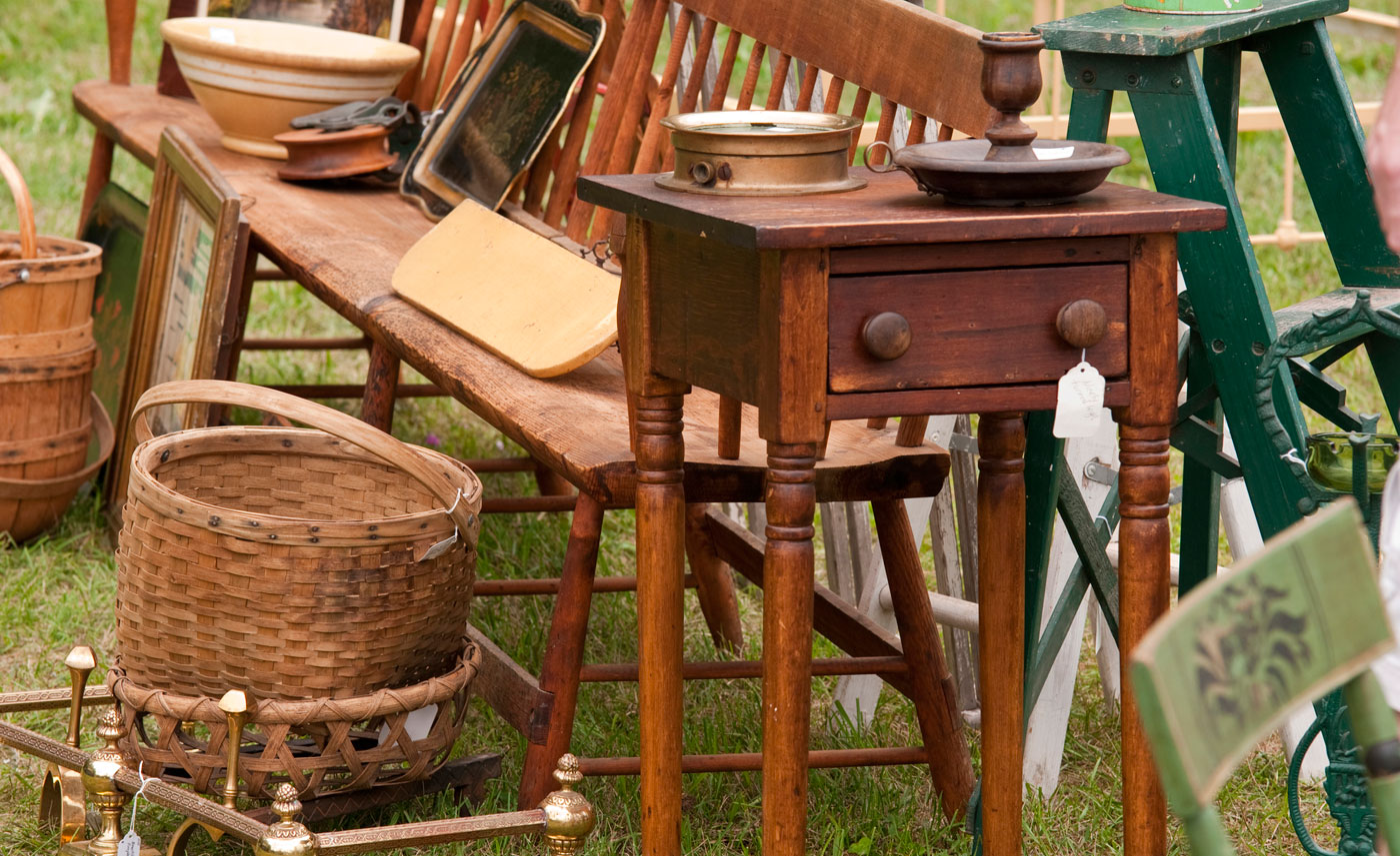 Wooden items at an estate sale including a bench, baskets, and a step stool