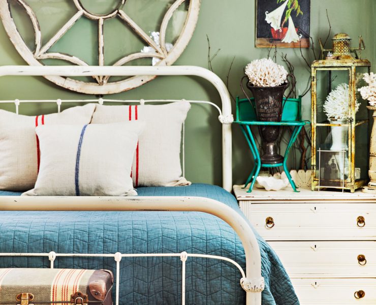 Bedroom with architectural salvage window hanging above the bedroom