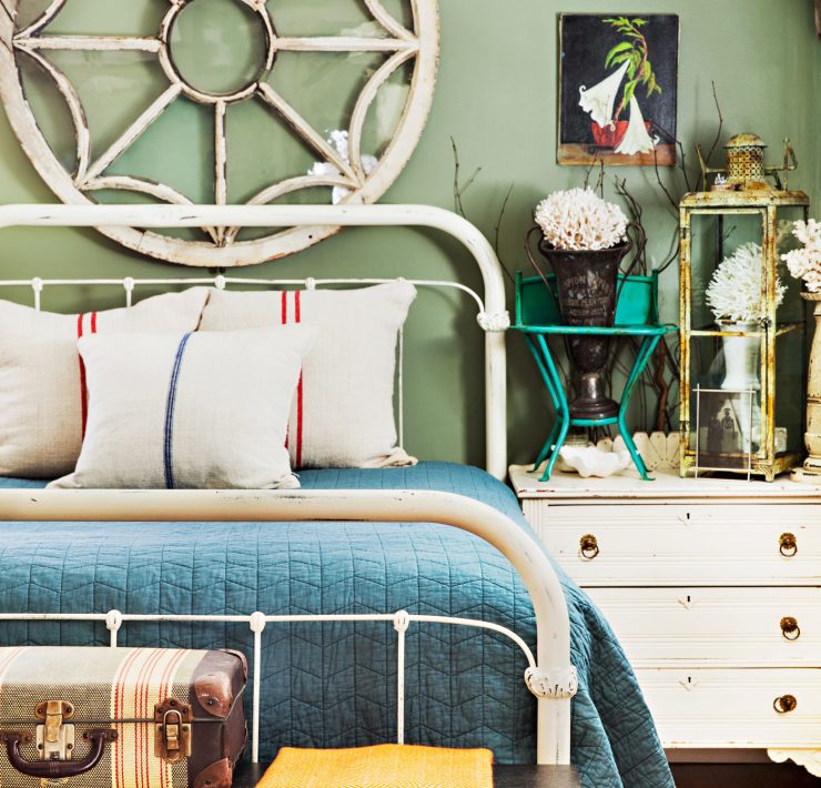 Bedroom with architectural salvage window hanging above the bedroom