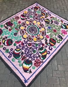 Of all vintage quilts, this one is unique with a pale pink background and bold, multi-colored Bohemian embroidered designs.