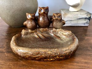 This brown ceramic soap dish has three little owls perched on the ledge.