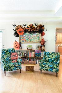 colorful chairs are featured in a family room decorated for a halloween party