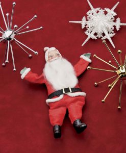 Vintage Santa Claus collectibles with snow flake ornaments against a red background