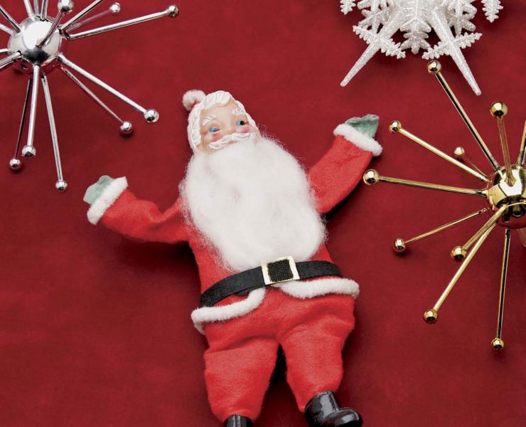 Vintage Santa Claus collectibles with snow flake ornaments against a red background