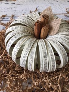 This faux pumpkin is made out of mason jar lids with strips of vintage text glued around them.