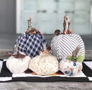 These faux pumpkins are made from patterned fabric with artificial leaf embellishments and real wood for stems.