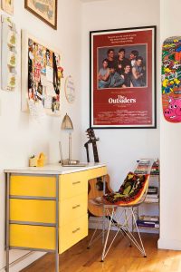 Yellow Mid Century Modern desk with molded plastic chair and bulletin board