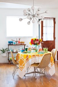 Sputnik chandelier above a Mid Century Modern table with a yellow tablecloth