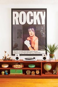 Rocky movie poster hung above a Mid Century Modern entertainment center filled with vintage collectibles