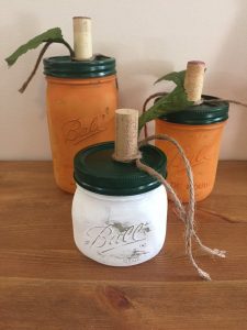 These faux pumpkins are painted mason jars with green lids and cork screws for stems.