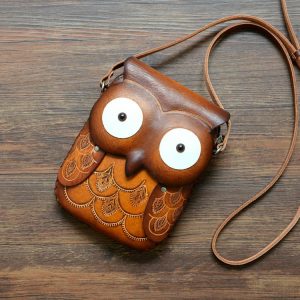 This leather cross-body bag has a flap that looks like an owl when closed.