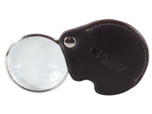 Travel-size magnifying glass with leather cover to prevent glass damage.