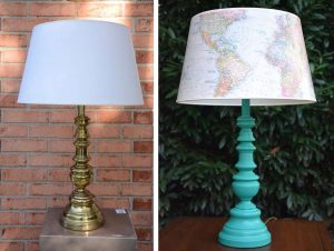 A vintage lamp with a turquoise base and a shade that displays a world map.