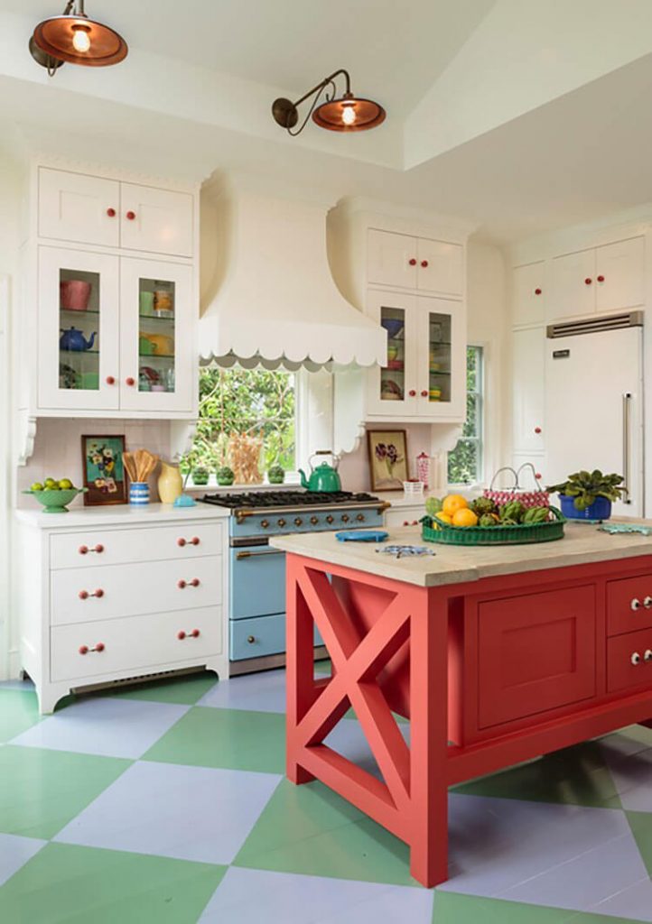 A kitchen with cabinets that are painted red to contrast with the white of the interior.