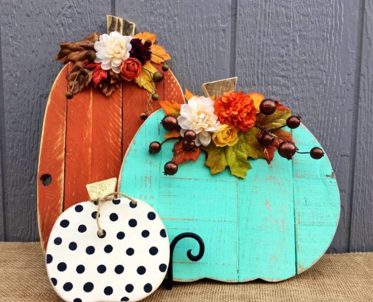 These three faux pumpkins are wood slats in the shape of pumpkins and painted orange, teal and white with black polka dots. They are embellished with artificial greenery.