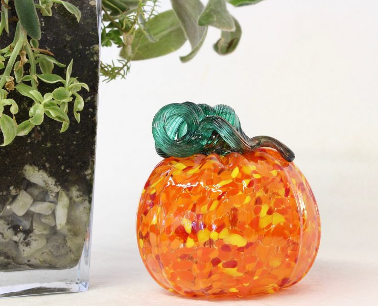 This faux pumpkin is made from hand-blown mottled orange glass with a curly green stem.