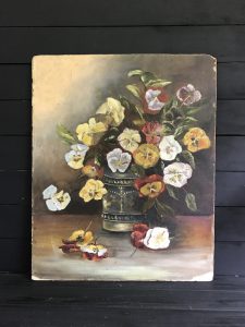 Mostly neutral scale painting of white, yellow and red pansies in an antique silver vase with some flowers on the table below.