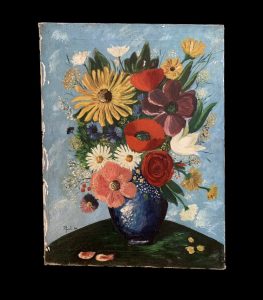 Colorful flowers in a dark blue vase with a sky blue background.