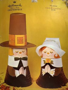 Vintage Thanksgiving paper cylinder-shaped dolls that look like pilgrims praying.