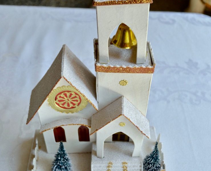 White chapel putz house that lights up and has a metal gold bell in the steeple.