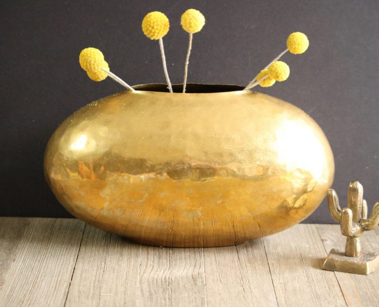 Hammered brass vase in the shape of a wide bowl.