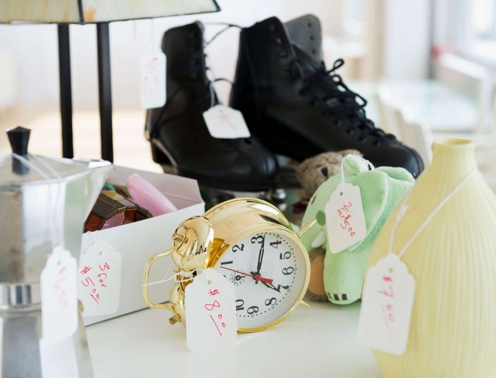 A pair of roller skates and vintage clocks with price signs on them.