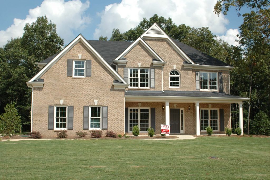 The exterior of a house with a red sign specifically for estate sales.