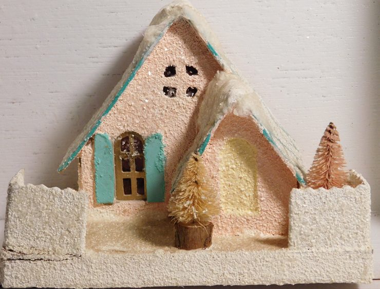Glittery, pale pink putz house with pale blue roof and shutters with faux snow.