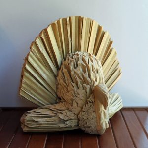 Vintage Thanksgiving turkey made out of dried cornhusks with a wooden head.