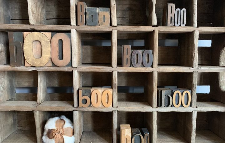 Letterpress letters spelling out "boo" in multiple different wood cubbies.
