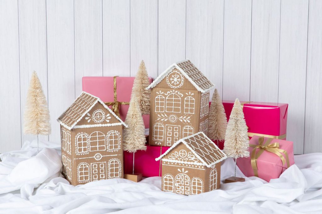 Cardboard made into gingerbread houses that are decorated with glue to look like snow.