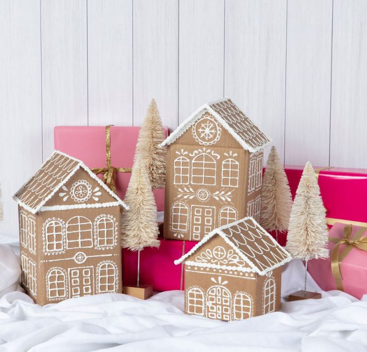 Cardboard made into gingerbread houses that are decorated with glue to look like snow.