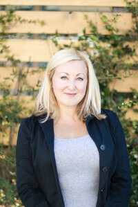 Natasha Pace, an estate liquidator, in front of a blurred background of folliage