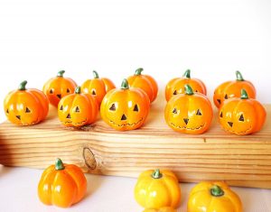 These faux pumpkins are mini orange ceramic jack-o-lanterns.