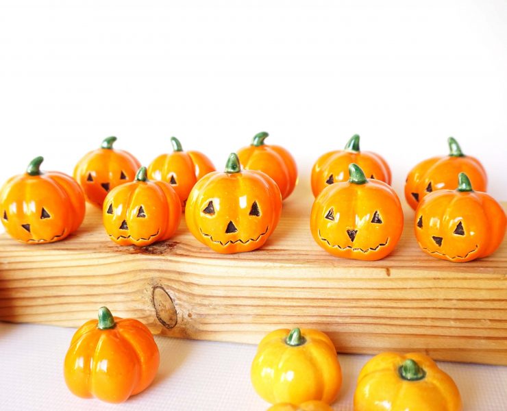 These faux pumpkins are mini orange ceramic jack-o-lanterns.