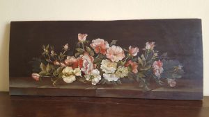 Pink and white, leafy flowers on a darkly painted wood board.