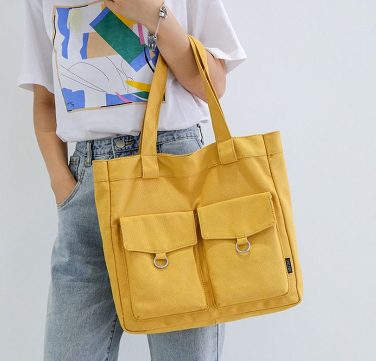 This yellow canvas bag is perfect for the flea market because of its thick straps and two outer pockets with flaps for extra storage.