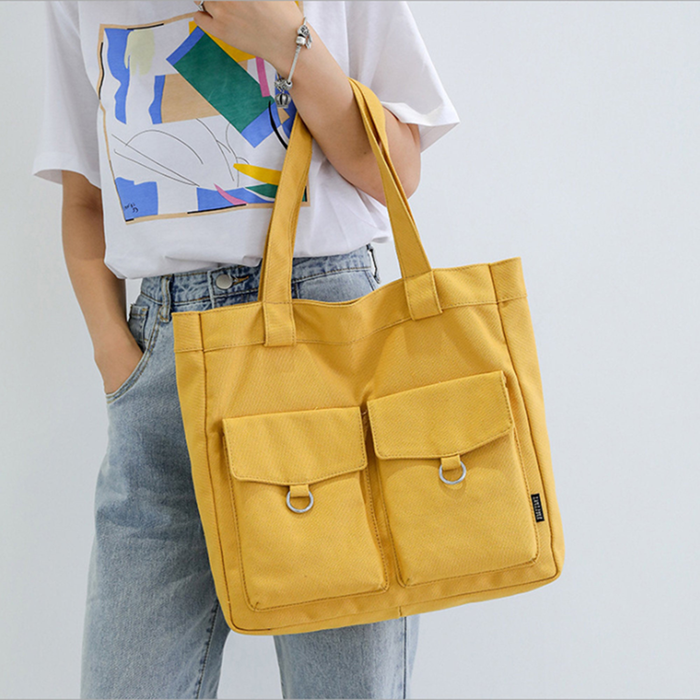This yellow canvas bag is perfect for the flea market because of its thick straps and two outer pockets with flaps for extra storage.