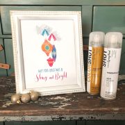 A white and gold frame showcases a holiday art printable with Shiny Brite ornaments. COLORSHOT spray paint is the product.