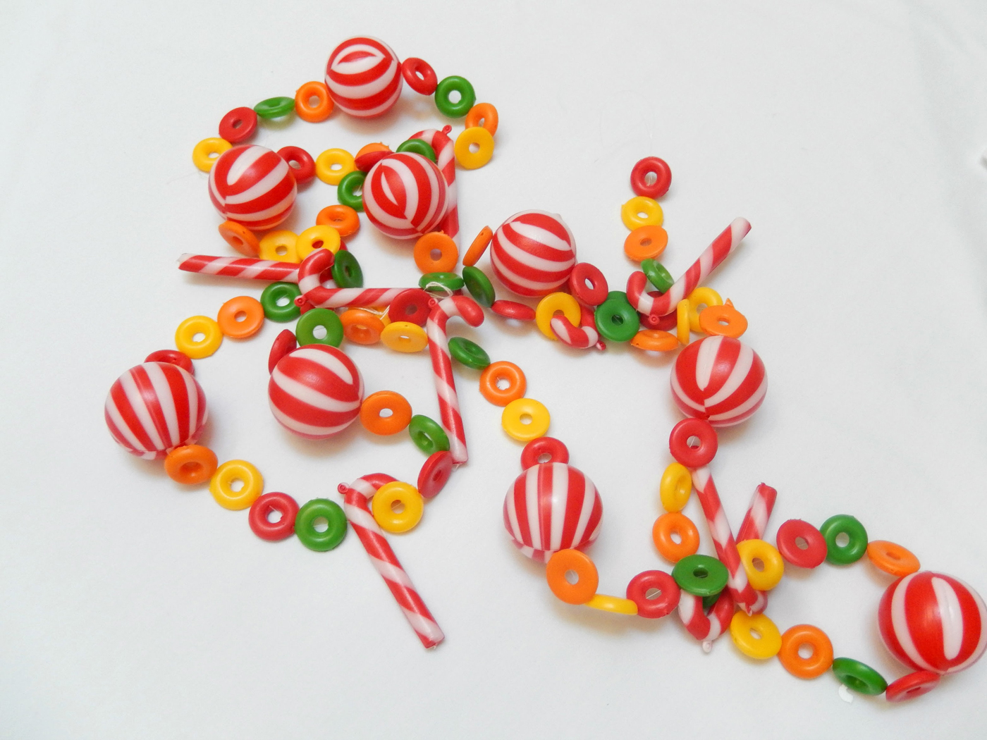 Vintage garland made out of plastic beads shaped like peppermints, candy canes and fruit loop cereal pieces.