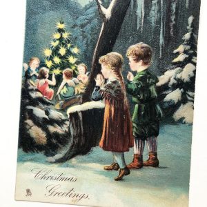 Postcard with two children in the snowy woods watching angels around a tree.