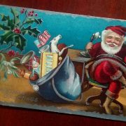 Santa chatting on an old-fashioned telephone with his sack of toys beside him.