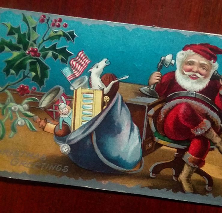 Santa chatting on an old-fashioned telephone with his sack of toys beside him.